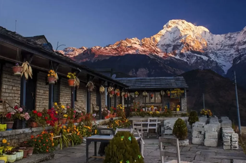 Annapurna base camp trek teahouse courtyard with tables and sunrise mountain view in the Annapurna region
