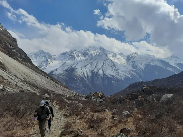 Trekkers walking along a mountain trail in the Langtang Valley of Nepal