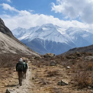 Langtang valley trek hikers walking a mountain trail with snow-covered Himalayan peaks