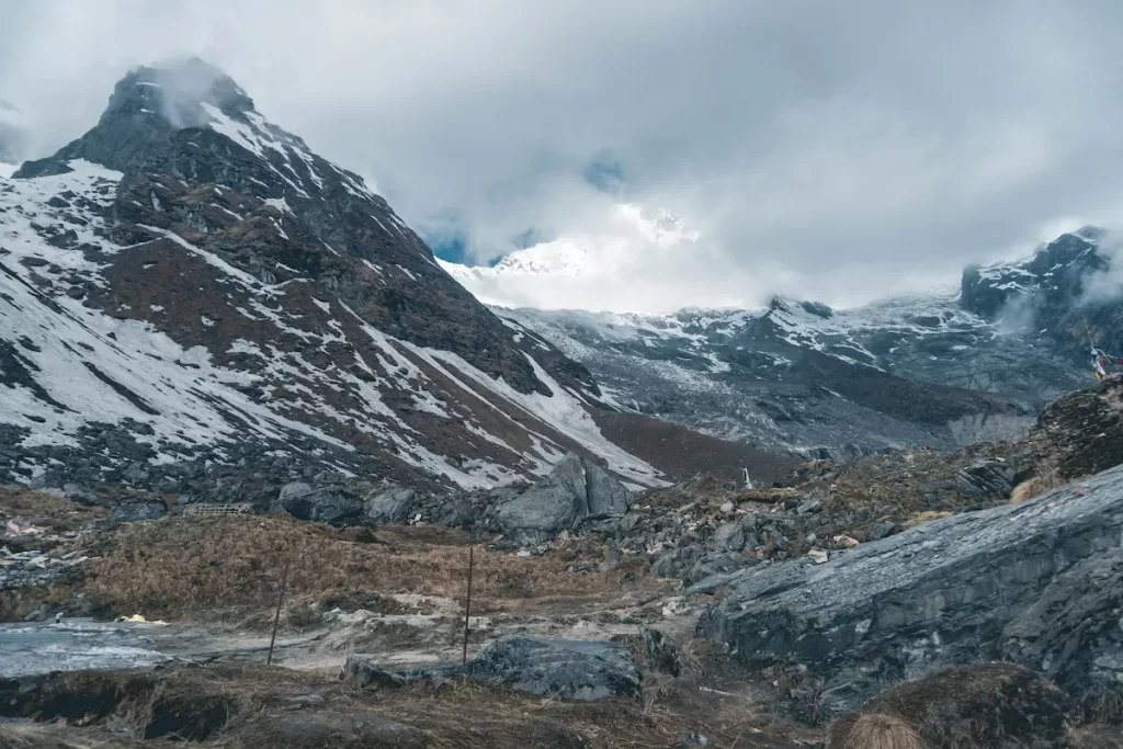 Langtang valley trek upper valley terrain with rocky trail and cloud cover in the Himalayas