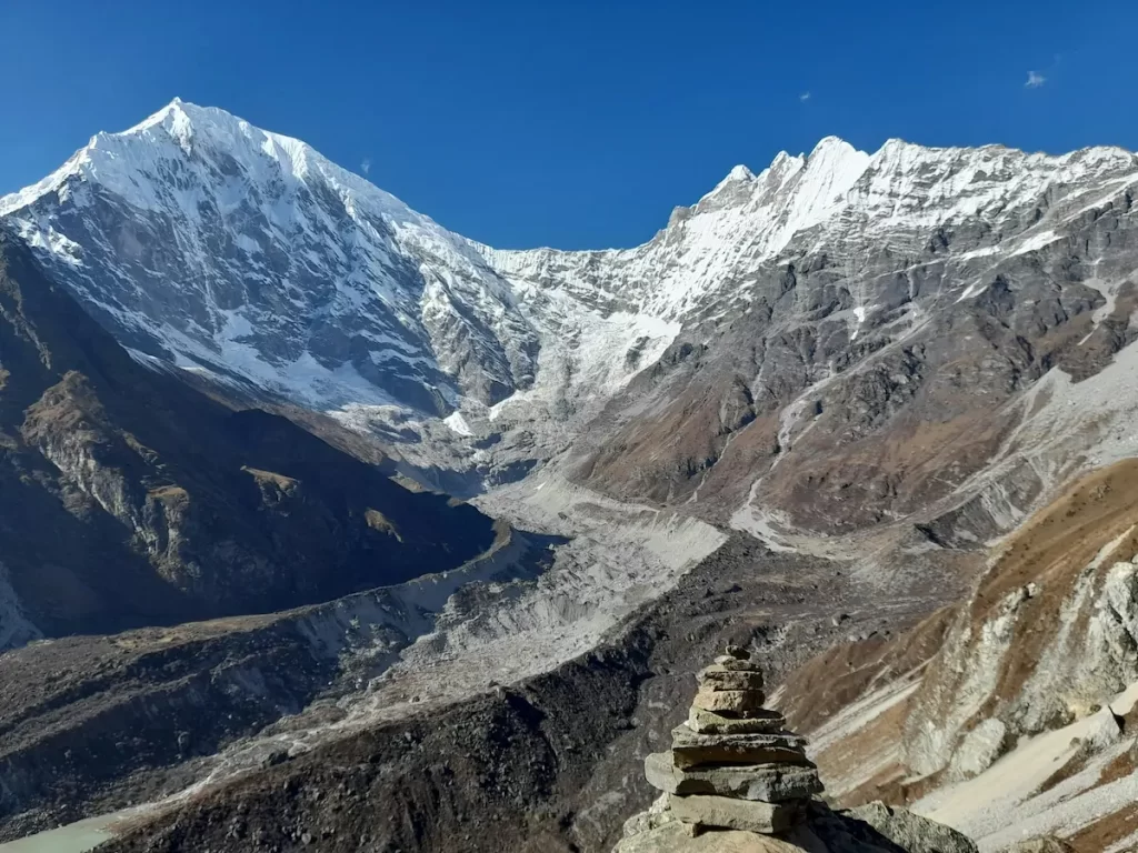 Langtang valley trek high alpine basin with cairn and snow-covered ridgelines at altitude